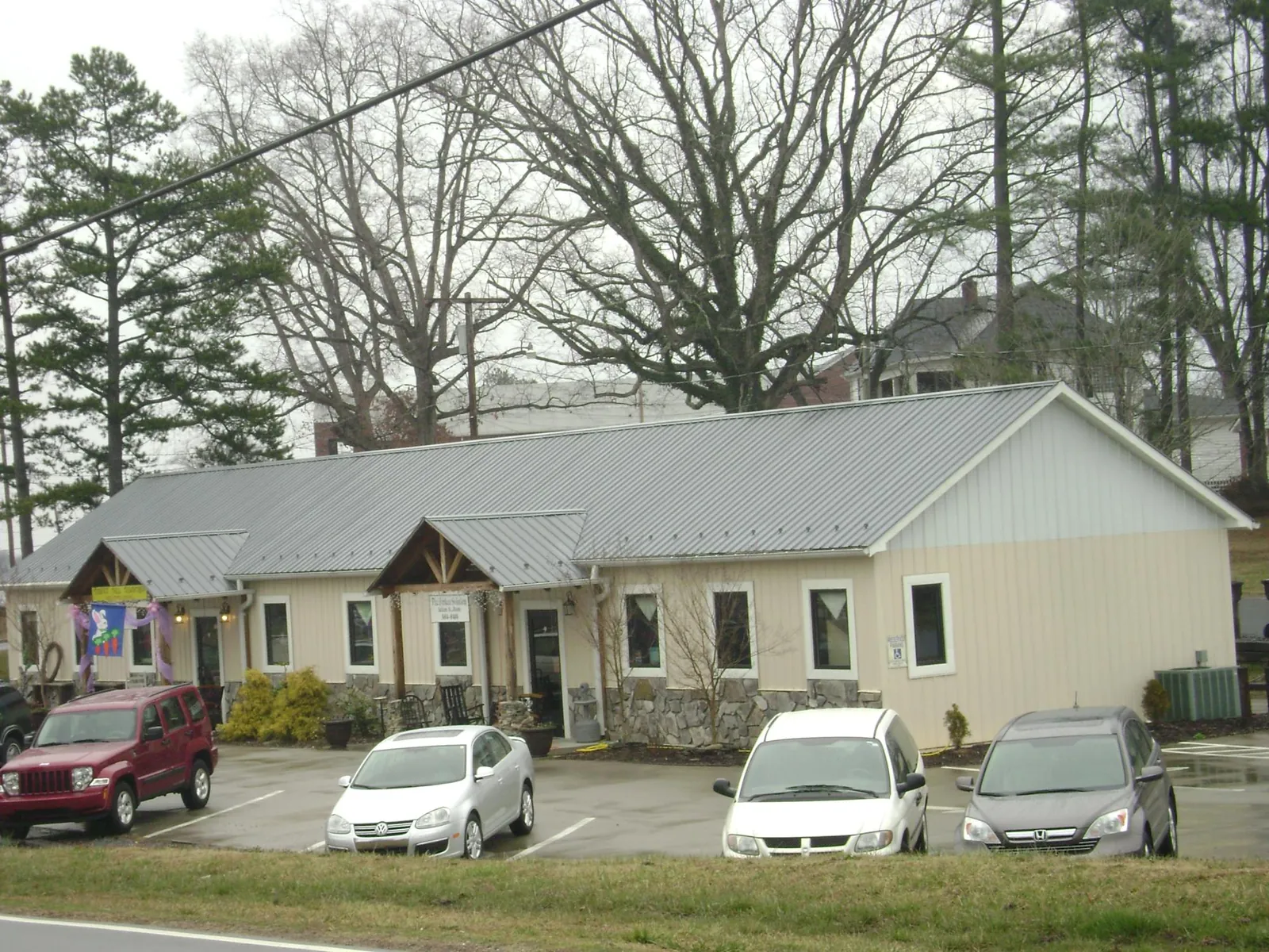 Gray metal roof with timber entry brackets on a small commercial building in Huxley